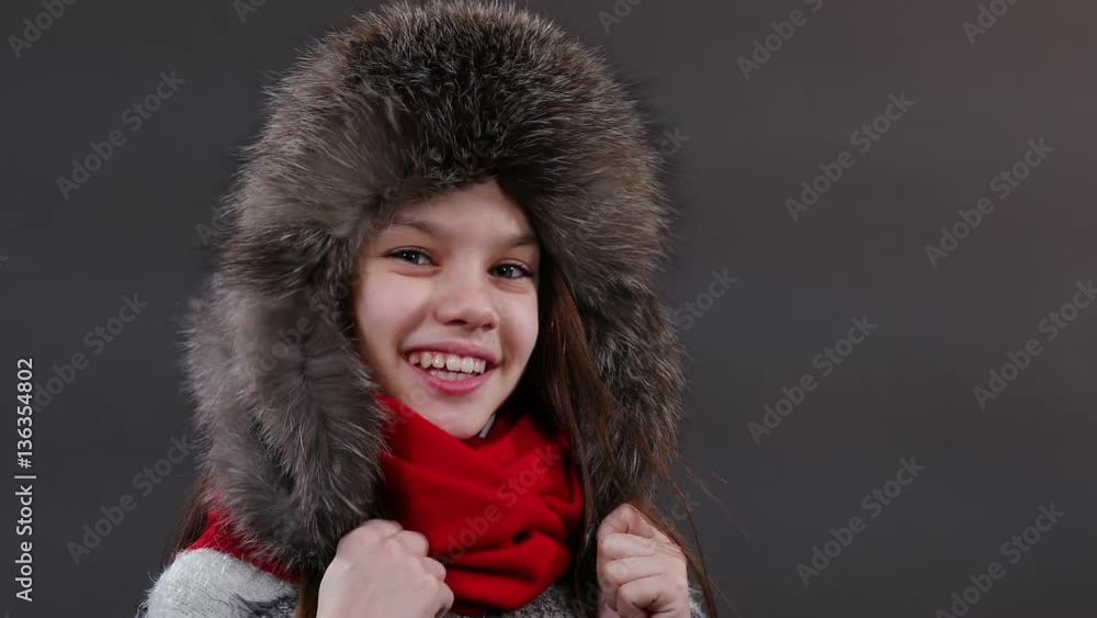 Beautiful little girl in a fur hat posing in studio. Video resolution of 4K Beautiful little girl in a fur hat posing in studio. Video resolution of 4K
