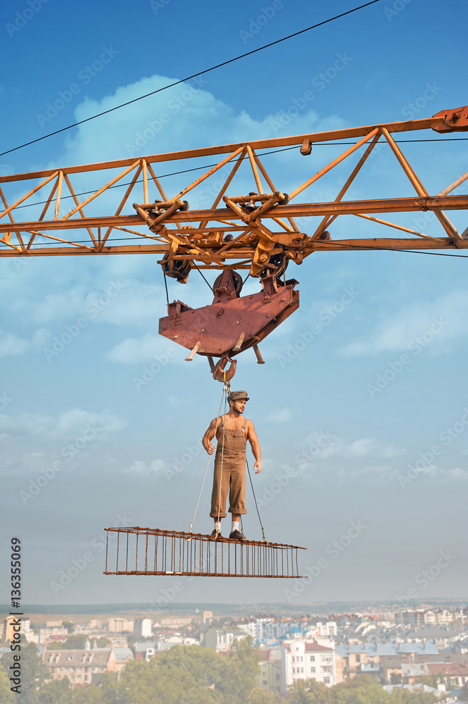 Athletic builder standing on construction on high. Athletic builder standing on construction on high.