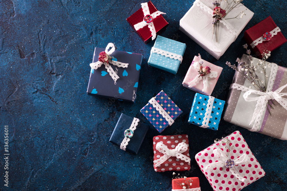 Fototapeta premium Presents for any holiday concept. Gift boxes frame, top view with copy space on darkblue table background. Border of packages for christmas, valentine day or birthday
