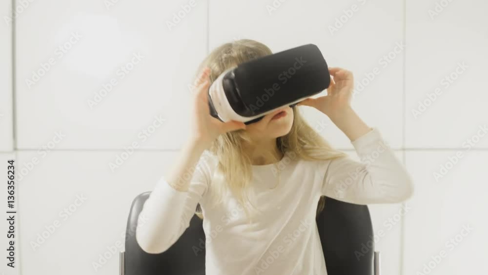 Lockdown shot of curious girl using virtual reality glasses while sitting on chair against white wall
Lockdown shot of curious girl using virtual reality glasses while sitting on chair against white wall