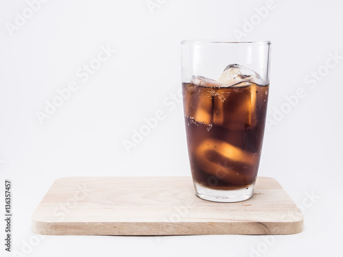 soft drink is cool with ice cubes  two of thirds in glass on wood squares
