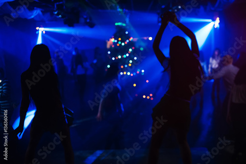 blurred silhouettes of two dancers on stage at the club at the party