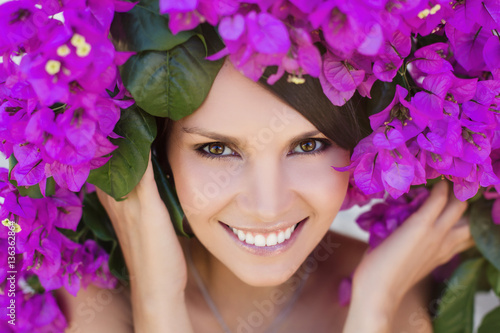 Portrait of beautiful young woman with flower wreath on her head and smiling
