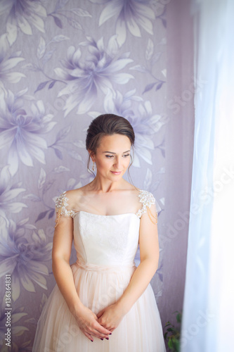Beautiful young bride with wedding makeup and hairstyle in bedroom. Closeup portrait of young gorgeous bride. Wedding hairstyle