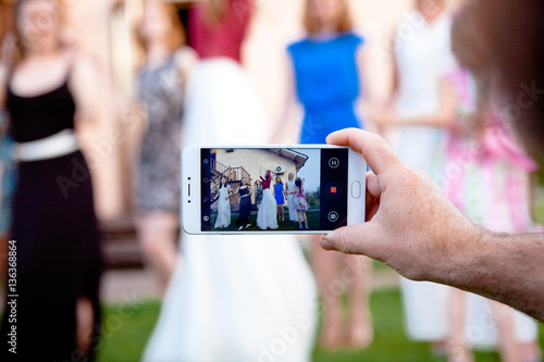 man use smartphone for take picture of dancing girls