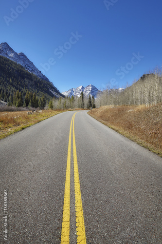 Scenic mountain road, Maroon Bells in distance, travel concept, USA. © MaciejBledowski