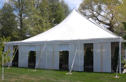 white party tent in a park setting 