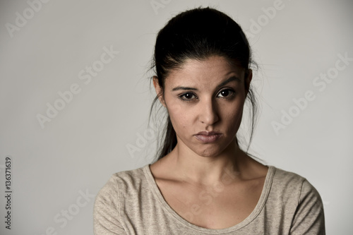 beautiful arrogant and moody spanish woman showing negative feeling and contempt facial expression