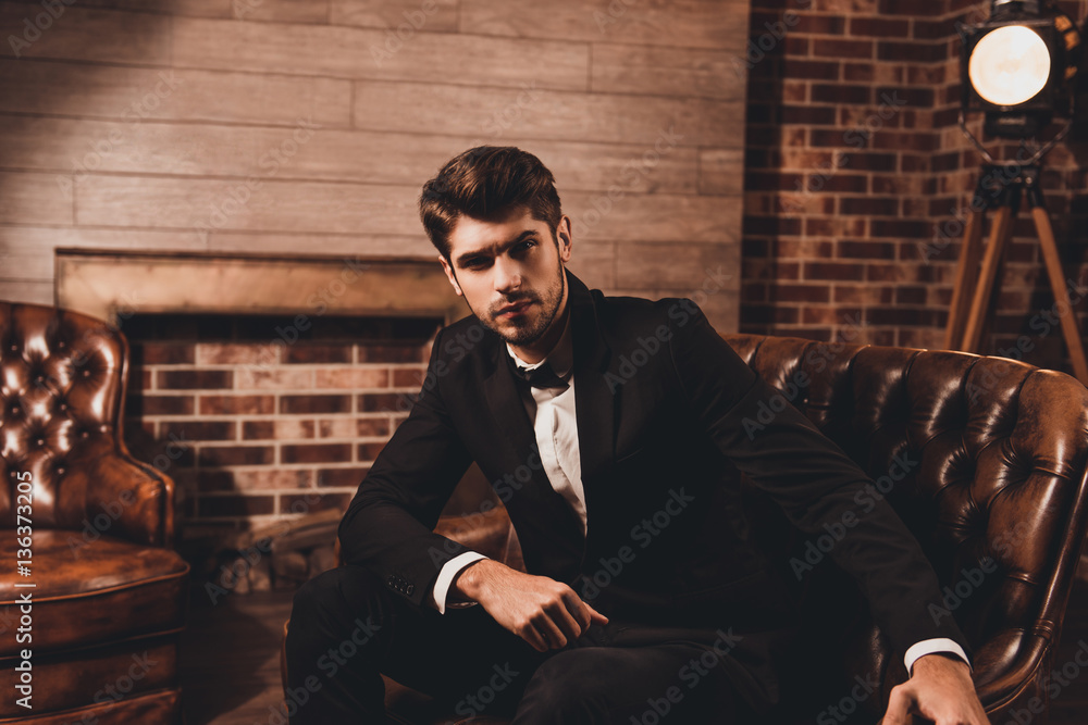 Portrait of handsome businessman in elegant black suit sitting o Portrait of handsome businessman in elegant black suit sitting o