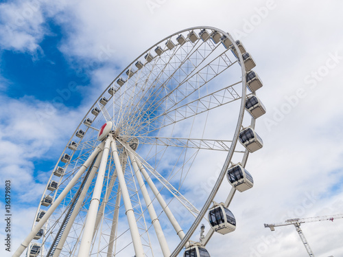 A Ferris wheel with vivid blue sky background, photographed outdoor with a wide angle lens.