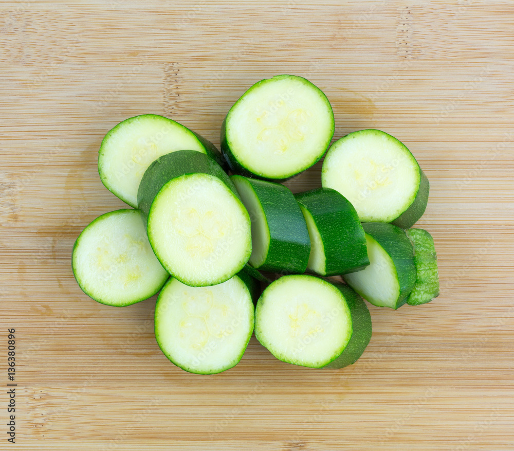 Italian squash slices on a wood cutting board top view. Italian squash slices on a wood cutting board top view.