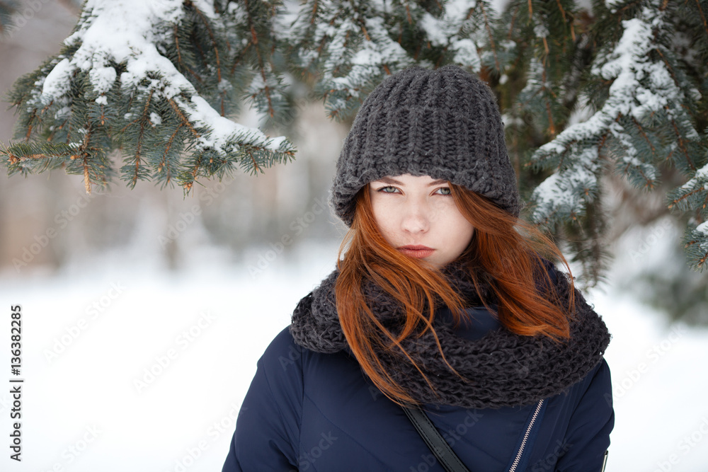 Closeup beautiful winter portrait of young adorable redhead woman in cute knitted hat winter snowy park Closeup beautiful winter portrait of young adorable redhead woman in cute knitted hat winter snowy park