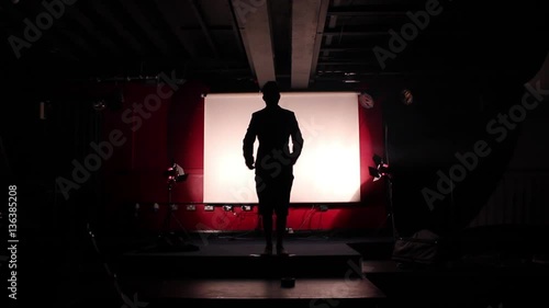 Man on stage takes a bow and thanks audience