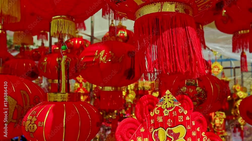 NHA TRANG, KHANH HOA/VIETNAM - JANUARY 26 2017: Wind shakes hung up large painted in gold red Chinese lanterns on street market before Vietnamese new year TET on January 26 in Nha Trang NHA TRANG, KHANH HOA/VIETNAM - JANUARY 26 2017: Wind shakes hung up large painted in gold red Chinese lanterns on street market before Vietnamese new year TET on January 26 in Nha Trang