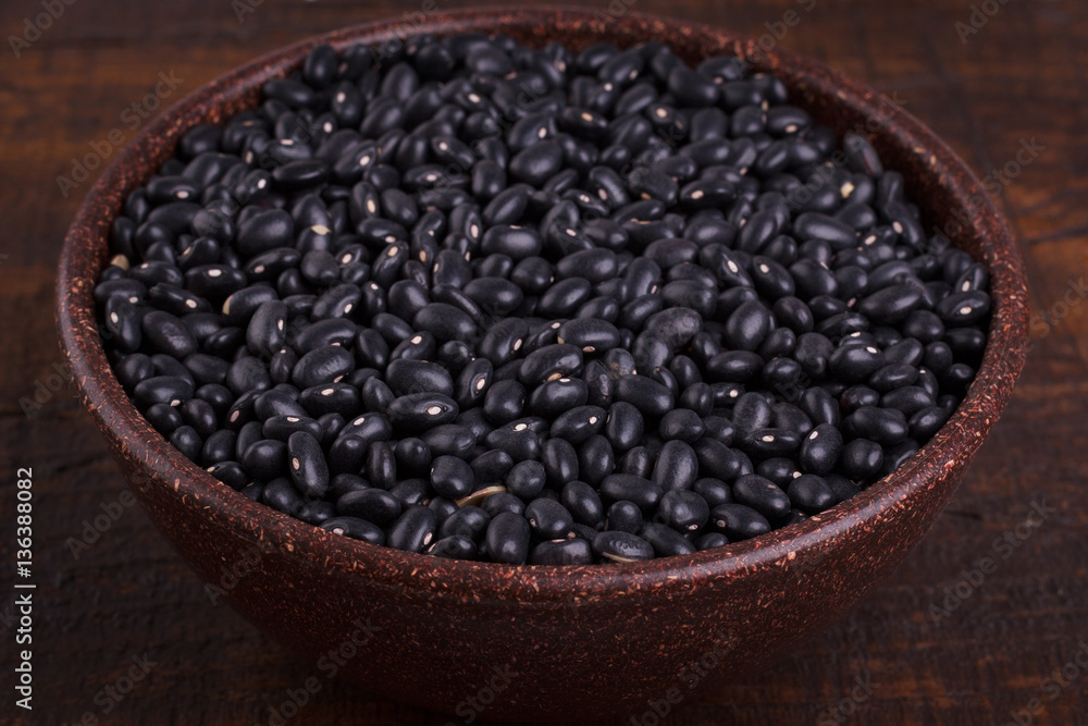 Black beans in scoop on wooden background Black beans in scoop on wooden background