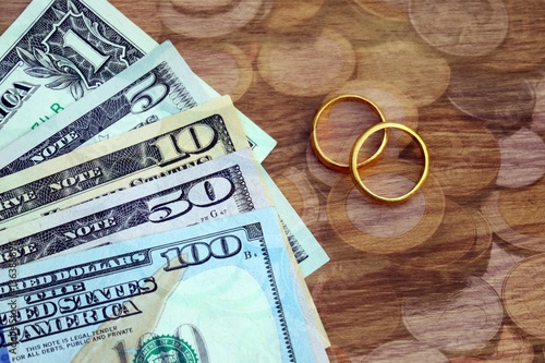 Golden wedding rings on Dollar banknotes cash background. Marriage of convenience. Double exposure