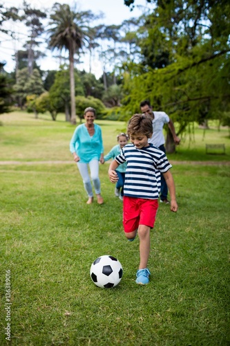 Happy family playing football in park