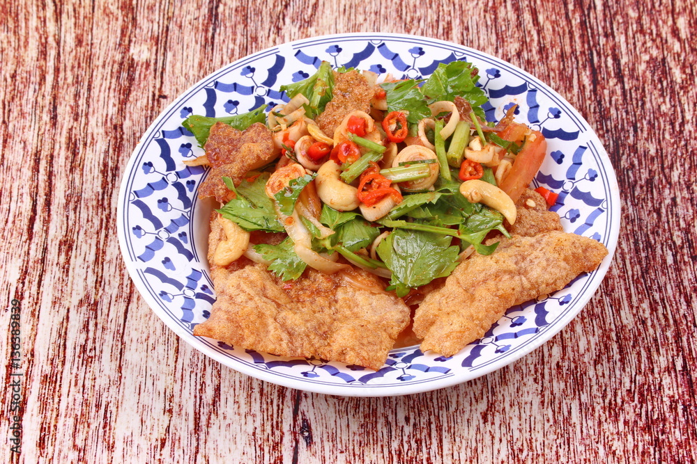 Spicy and sour mixed herb salad with crispy pork served . Spicy and sour mixed herb salad with crispy pork served .