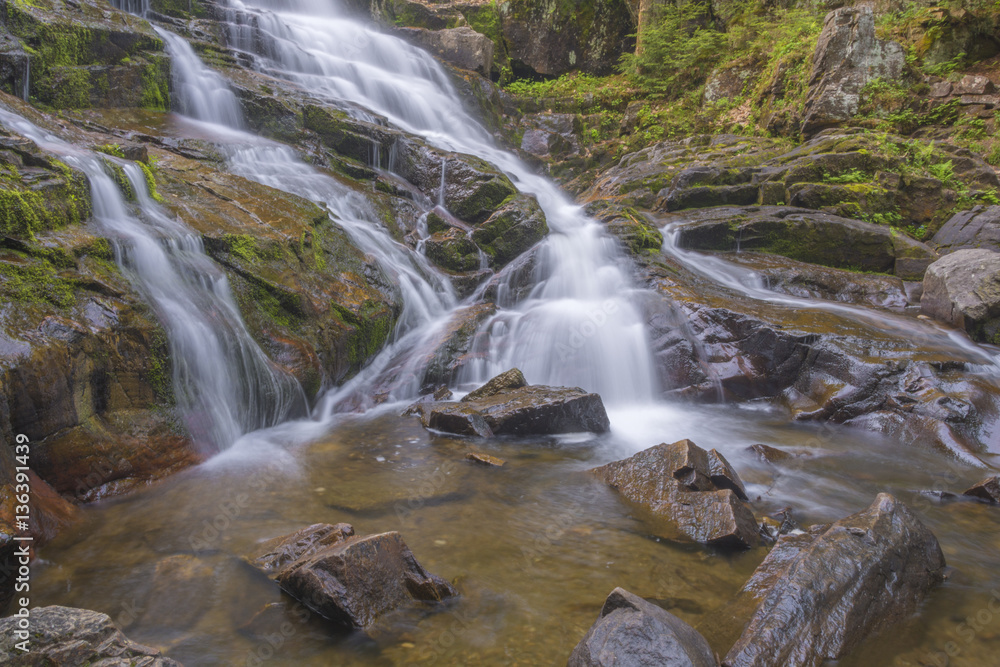 Fototapeta premium Waterfall Flows Down Warm Colored Bedrock