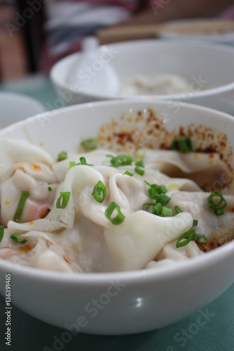 Steamed Chinese dumplings with hot sauce and green onions served in a bowl, Chengdu, Sichuan province, China