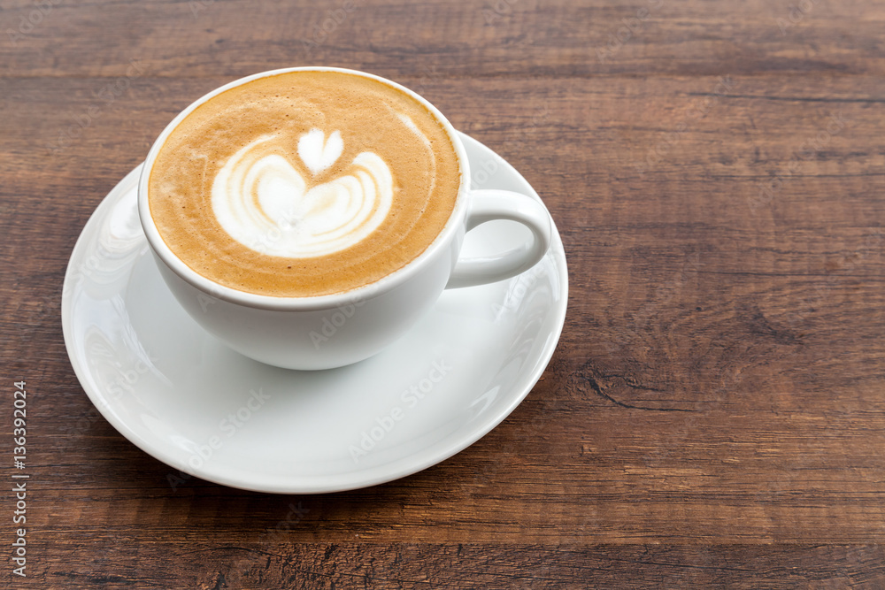 Coffee cup of latte art on wooden background with copy space