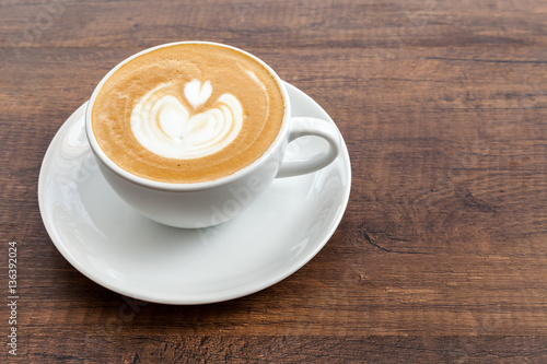 Coffee cup of latte art on wooden background with copy space