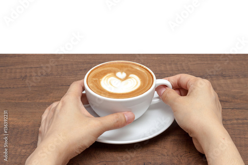 Obraz na płótnie Hand holding coffee cup of latte art on wooden table with white w salonie