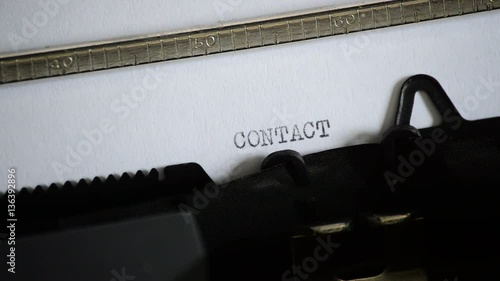 Typing the word CONTACT with an old manual typewriter photo