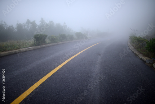 Road in heavy fog. A crooked road turn into mist. Full of mysterious, misty and dangerous feelings.