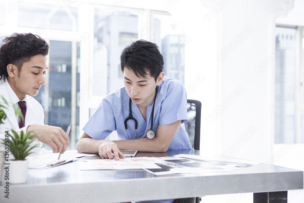 Two doctors are talking in the examination room Two doctors are talking in the examination room