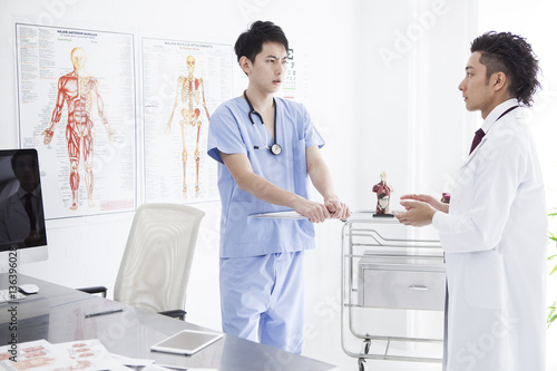 Two doctors are seriously talking in the examination room