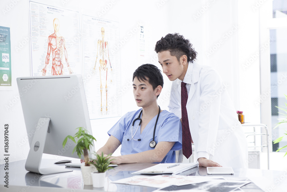 Two doctors are watching a computer together Two doctors are watching a computer together