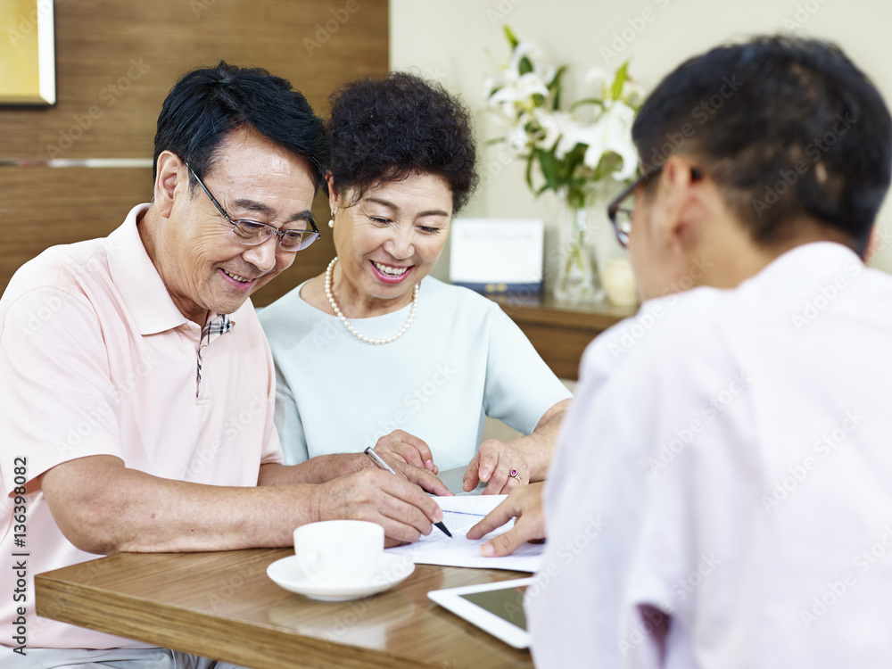 senior asian couple signing a contract senior asian couple signing a contract