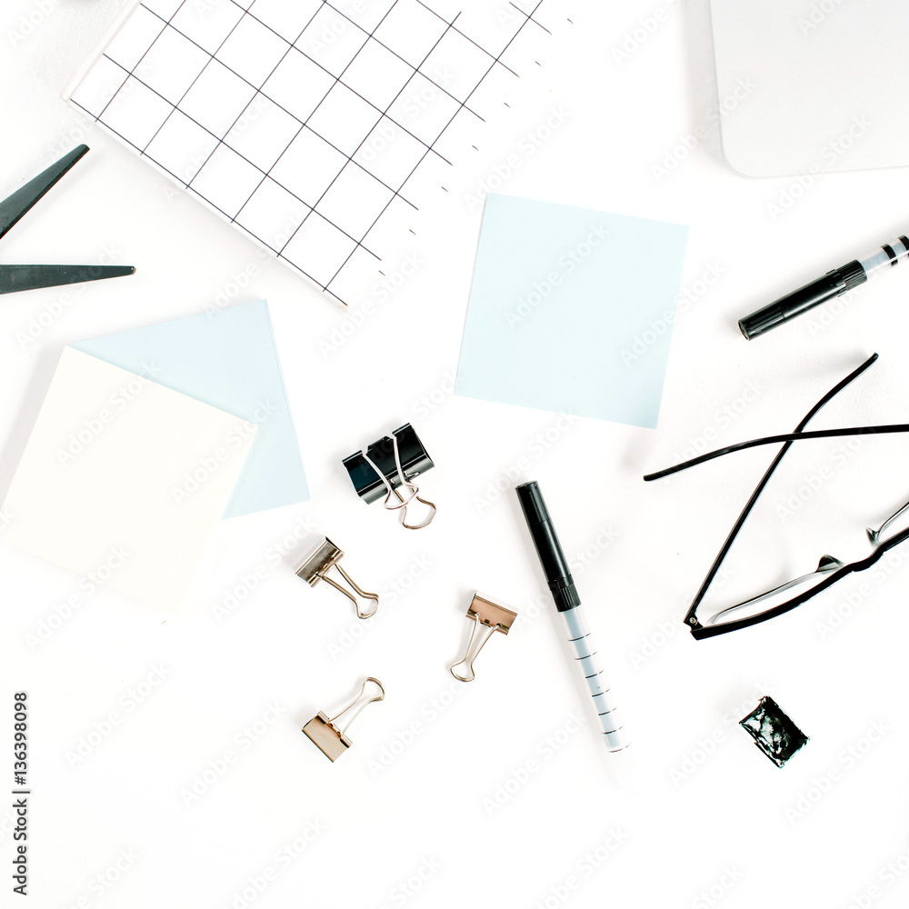 White office desk frame with paper blank and supplies. Laptop, notebook, pen, clips, glasses and office supplies on white background. Flat lay, top view, mockup. White office desk frame with paper blank and supplies. Laptop, notebook, pen, clips, glasses and office supplies on white background. Flat lay, top view, mockup.