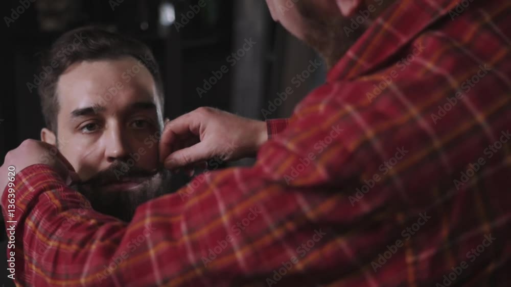 Portrait brutal bearded hipster man in the barber shop and He twists his mustache Portrait brutal bearded hipster man in the barber shop and He twists his mustache