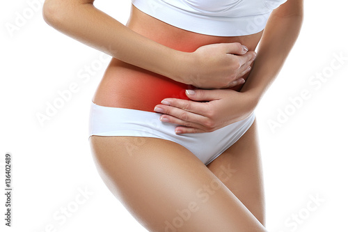 Gynecology concept. Young woman suffering from pain, white background