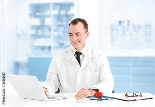 Doctor sitting at table in ...