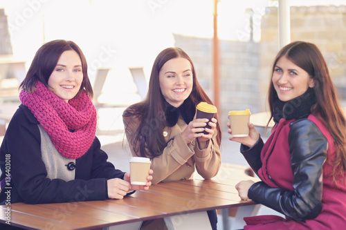 Cheerful young women drinki...