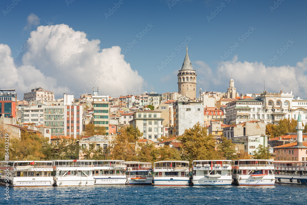 Sunny view of Bosphorus with excursion boats and Galata Tower, Istanbul, Turkey.