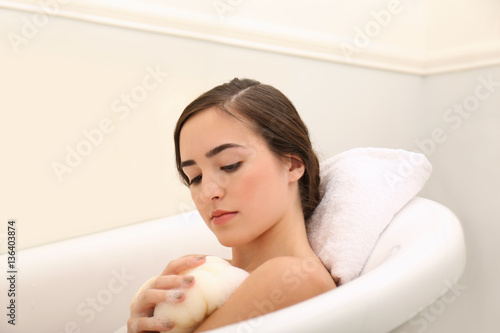 Young beautiful woman taking bubble bath