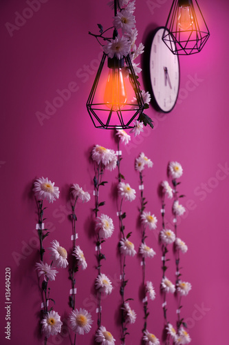 Lamps and wall decorated with flower garland © Africa Studio