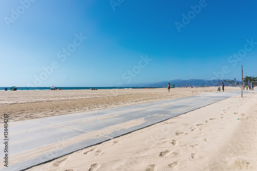 Empty beach with roller road near the sand. Clear sky in sunny weather in California