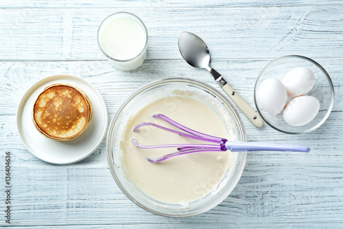 Ingredients for preparation of pancakes, on wooden background