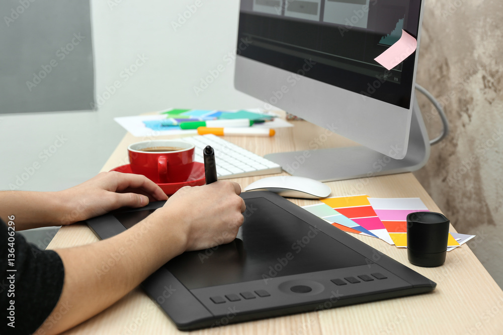 Fototapeta premium Young designer drawing sketches on graphic tablet