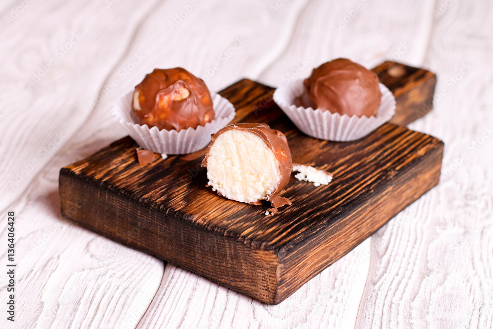 Handmade chocolate coconut candy on wooden table Handmade chocolate coconut candy on wooden table