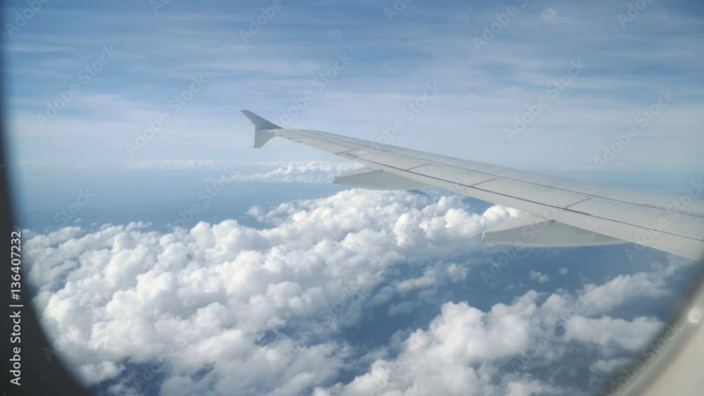 View through an airplane window on the tropical island, ocean, sky and clouds. Aerial view sea, clouds and sky as seen through window of an aircraft. 4K video. Aerial footage. Travel concept. View through an airplane window on the tropical island, ocean, sky and clouds. Aerial view sea, clouds and sky as seen through window of an aircraft. 4K video. Aerial footage. Travel concept.