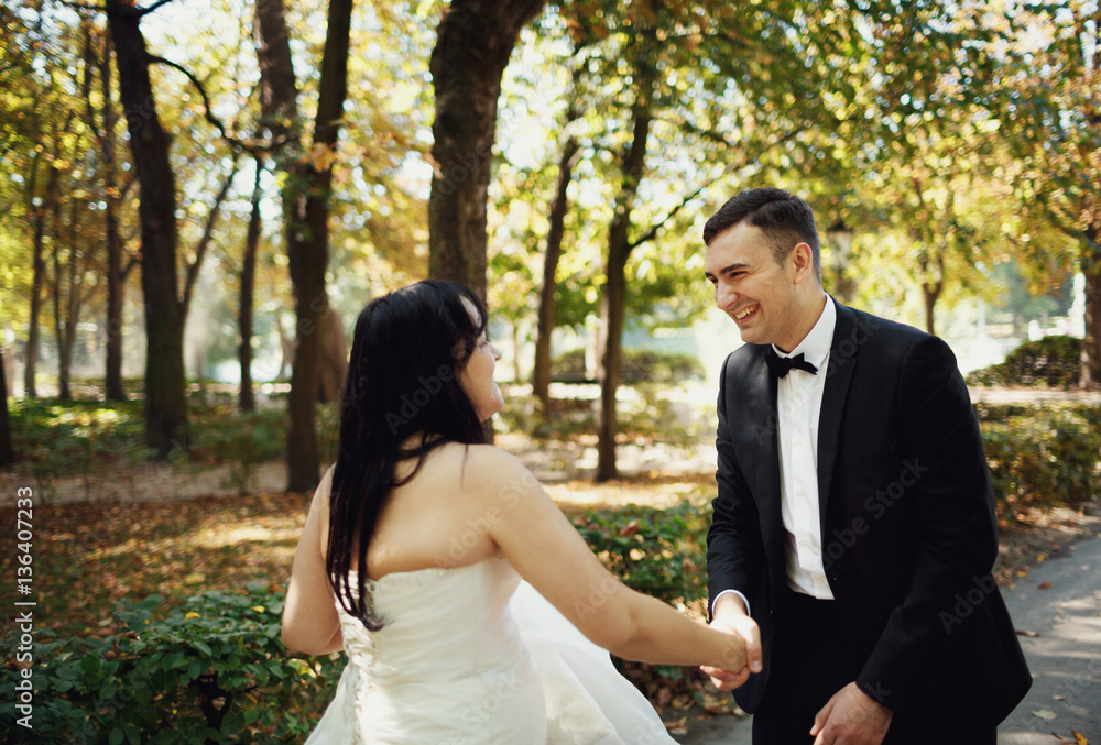 Amusing groom is holding a hand of his bride Amusing groom is holding a hand of his bride