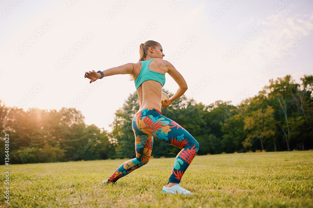 Young athletic girl playing with flying disc in the park. Professional player. Sport concept Young athletic girl playing with flying disc in the park. Professional player. Sport concept