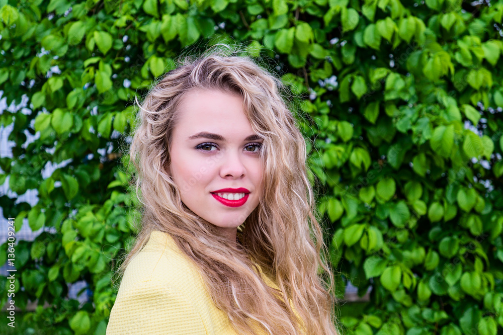 Attractive blonde in yellow coat emotionally posing at park Attractive blonde in yellow coat emotionally posing at park