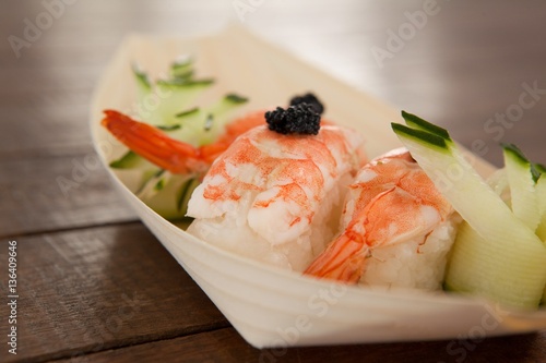 Three nigiri sushi served in wooden boat plate